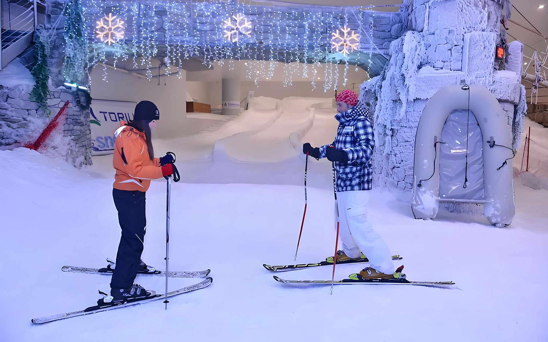 Skiing area featuring an artificial snow slope for skiing and winter sports activities in an indoor snow park.